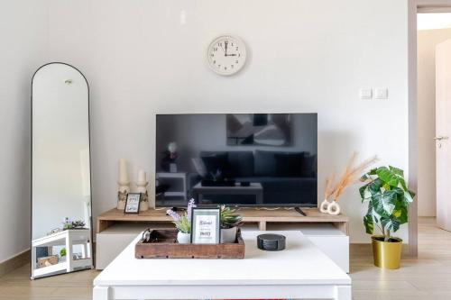 a living room with a tv and a white table at F1 - A Place to Stay 1BR Waters Edge Yas Island - Theme Parks in Abu Dhabi