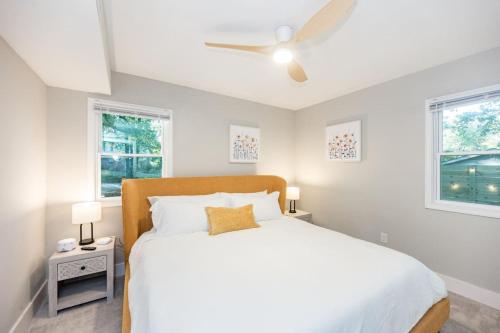 una camera con un letto bianco e due finestre di 3mi to Downtown Hot Tub Fire Pit a Garner