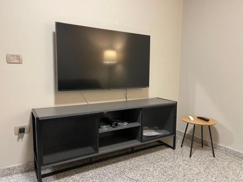 a black entertainment center with a flat screen tv on a wall at Dimora Vibo Centro in Vibo Valentia