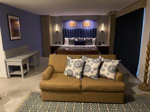 a living room with a couch and a bed at Hotel HBlue Malecón in La Paz