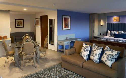 a living room with a couch and a table and a bed at Hotel HBlue Malecón in La Paz