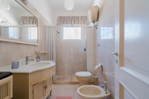 a bathroom with a sink and a toilet and a shower at Fronte Mare Villa Raffaele in Punta Prosciutto