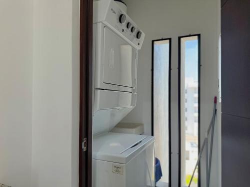 a white refrigerator in a room with a window at Depa en el Centro Historico By GPSRentas in Isla Cardones