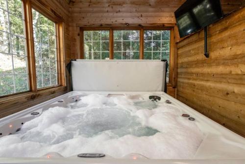 a jacuzzi tub in a room with snow at Summit Retreat Seven Springs in Champion