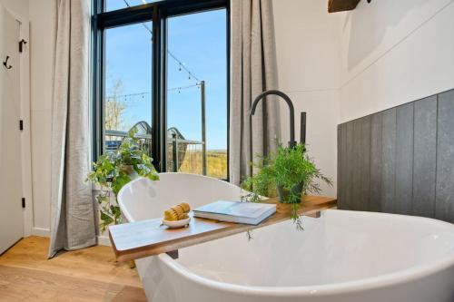 a bath tub in a bathroom with a large window at Alpine Abode - Hot Tub, Nature in Brookville
