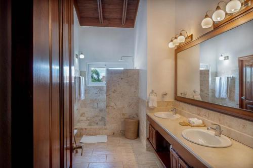 ein Badezimmer mit zwei Waschbecken und einem großen Spiegel in der Unterkunft Villa Polo Luxury Villa in Casa de Campo, La Romana in La Romana