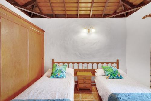 ティハラフェにあるCasa Serraderoのベッド2台とテーブルが置かれた寝室