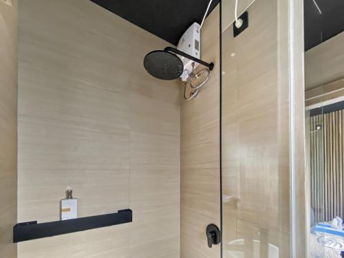 a bathroom with a shower with a glass door at Villa Byu By Local Property Team in Balian