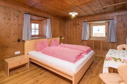 a bedroom with a bed in a wooden cabin at Ausserharmerhof App Anno 1556 in Santa Maddalena in Casies