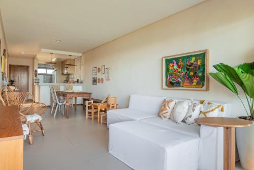 a living room with a white couch and a table at Bali Bahia 202 Frente ao mar Itacimirim in Itacimirim