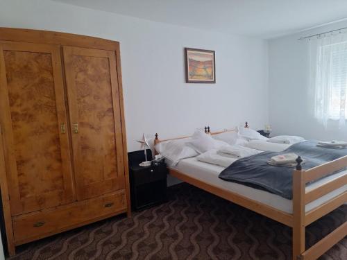 a bedroom with a bed and a wooden cabinet at Topole 2 