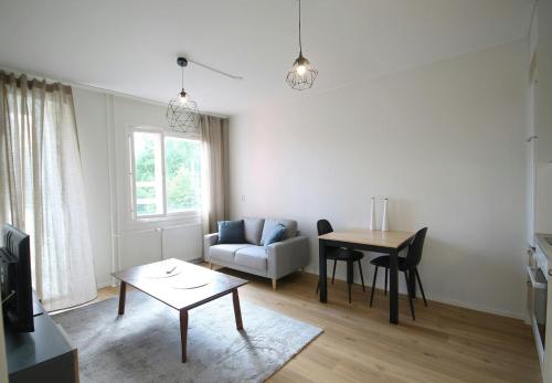 een woonkamer met een bank en een tafel bij Convenient Apartment for 2 in Kouvola