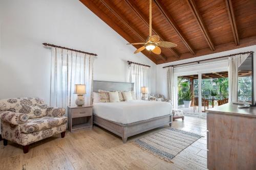ein Schlafzimmer mit einem Bett, einem Sofa und einem Ventilator in der Unterkunft Villa Polo Luxury Villa in Casa de Campo, La Romana in La Romana