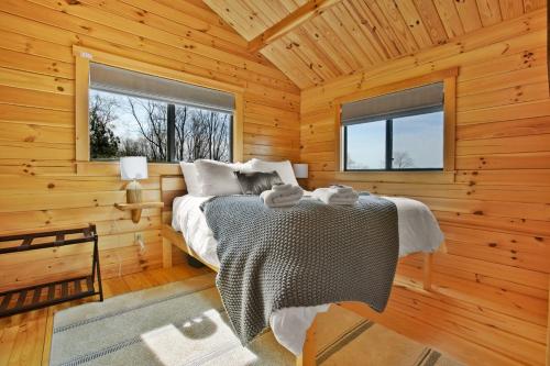 a bedroom with a bed in a wooden cabin at Sanctuary Summit - Hot Tub in Brookville