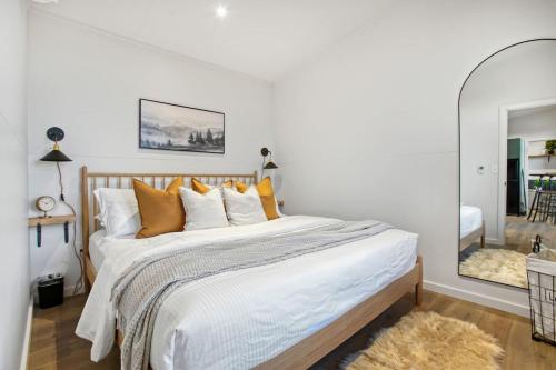 a bedroom with a bed with orange pillows and a mirror at Skyline Serenity - Hot Tub in Brookville