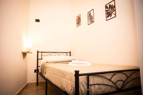 a bedroom with a bed and three pictures on the wall at San Nicola House in Enna