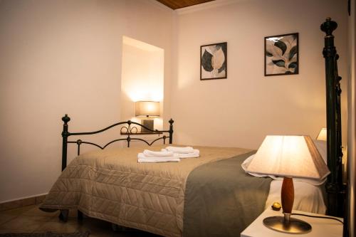 a bedroom with a bed with a lamp and towels on it at San Nicola House in Enna