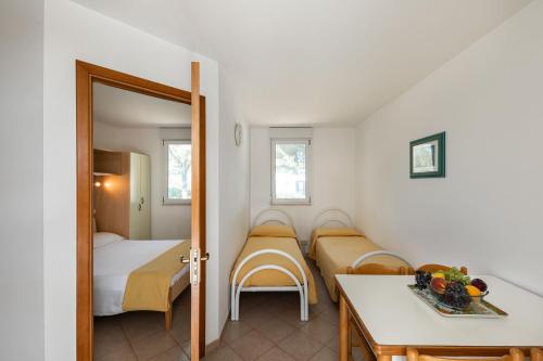 a small room with two beds and a table at Residence Camping Atlantide in Faccia di Trippa