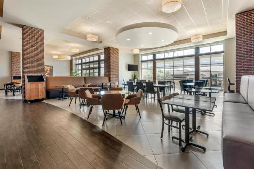 Un comedor con mesas y sillas y ventanas. en Drury Plaza Hotel San Antonio North Stone Oak, en San Antonio