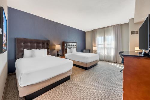 a hotel room with two beds and a television at Drury Plaza Hotel San Antonio North Stone Oak in San Antonio
