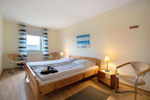 a bedroom with a bed and two chairs at Ferienwohnung Postel in Meldorf