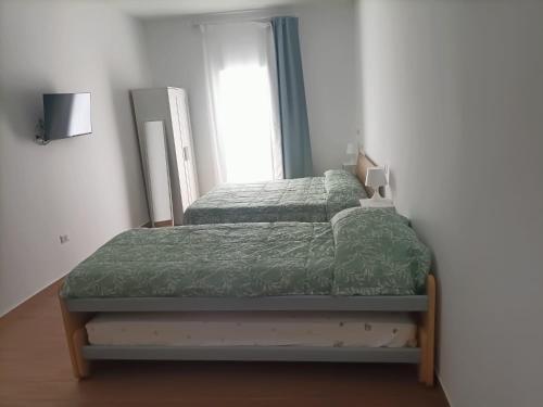 a bedroom with two beds and a window at D&D home in Mola di Bari