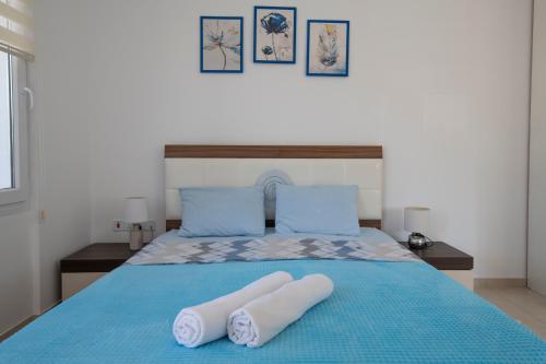 a bedroom with a blue bed with two towels on it at Студия в жилом комплексе Caesar Beach D1 Flat10 in Boğaz