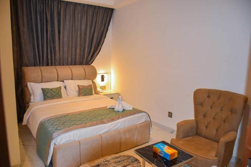 a hotel room with a bed and a chair at Viva Hôtel Ouaga 2000 in Ouagadougou
