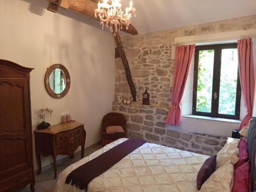 Schlafzimmer mit einem Bett, einem Fenster und einem Kronleuchter in der Unterkunft Idyllic Private Island Watermill Paradise in Roquebrune