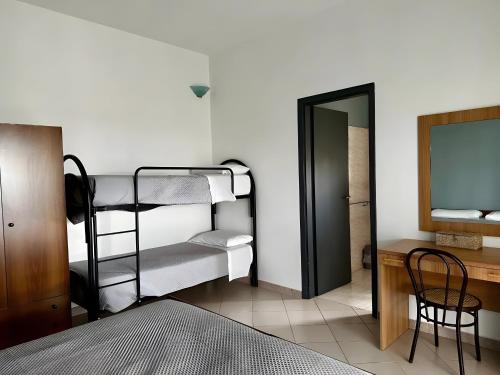 a bedroom with bunk beds and a desk and a mirror at L'aia di San Giorgio in Vignacastrisi