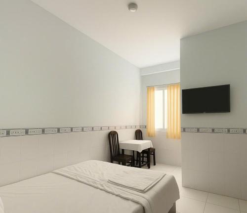 Un dormitorio con una cama, una mesa y un televisor. en CKC Motel - Near Can Tho City Center, en Can Tho