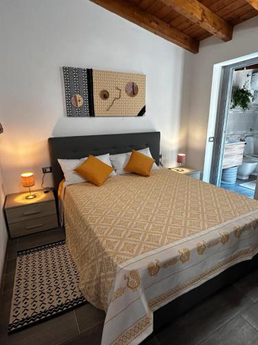 a bedroom with a large bed with yellow pillows at Casa Ipogeo in SantʼAntìoco