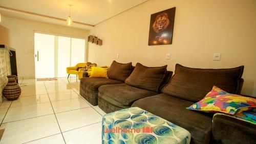 uma sala de estar com um sofá castanho e uma mesa em Casa em Rondonopolis com area gourmet em Rondonópolis