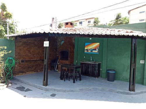 a patio with a table and a green building at Pousada e Hostel F C in Natal