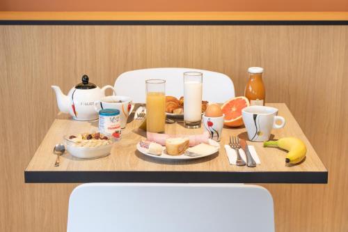 a table with breakfast foods and drinks on it at Brit Hotel Avignon Sud Le Calendal in Avignon