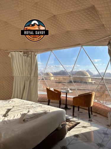 een slaapkamer met een bed en uitzicht op de woestijn bij ROYAL SAVOY lUXURY CAMP in Wadi Rum