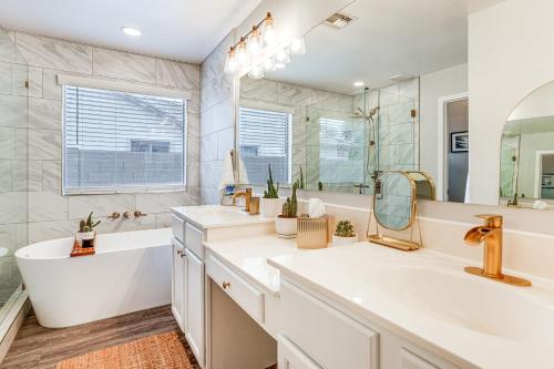 GermannにあるPool Access! Suburban Home 11 Mi to Dtwn Gilbertの洗面台が2つと浴槽と鏡があるバスルーム