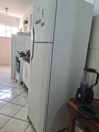 ヴィトリア・ダ・コンキスタにあるApartamento Térreo Com Portaria 24hのミキサー付きキッチン(白い冷蔵庫付)