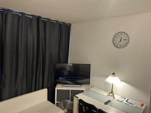 ein Hotelzimmer mit Fernseher und Wanduhr in der Unterkunft Sabrine E-biks in Kaiserslautern