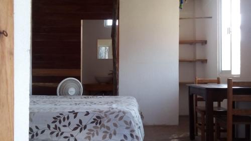 a bedroom with a bed and a table and a mirror at Cafe Maya - Casa Acalli in Zipolite