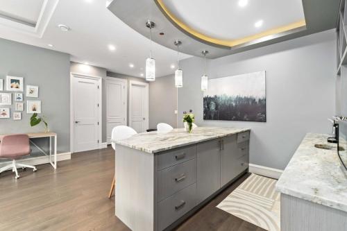 a kitchen with white cabinets and a marble counter top at Family guest suite in Marpole in Vancouver
