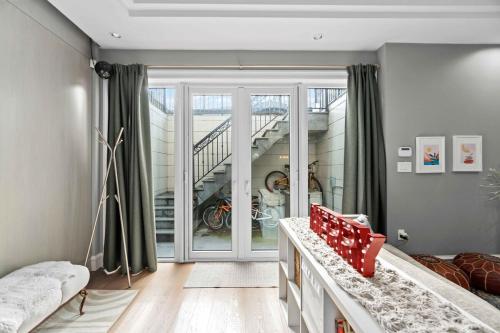 a living room with a staircase and a red chair at Family guest suite in Marpole in Vancouver