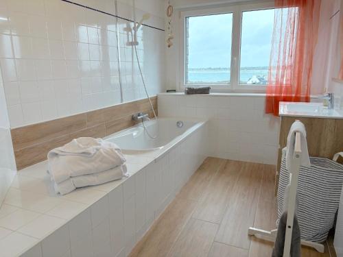 ein weißes Badezimmer mit Badewanne und Fenster in der Unterkunft Villa Armoréa in Sibiril