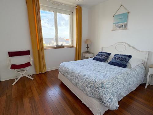 ein Schlafzimmer mit einem Bett mit blauen Kissen und einem Fenster in der Unterkunft Villa Armoréa in Sibiril