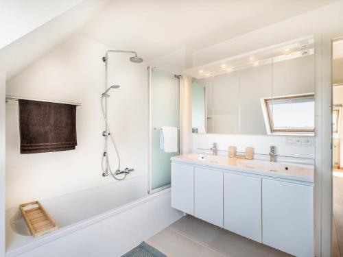 ein weißes Badezimmer mit Badewanne und Waschbecken in der Unterkunft Aan Zee in Galopen