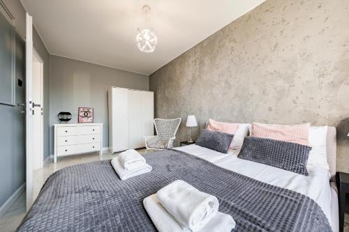 Un dormitorio con una cama grande con toallas. en Apartment Seaside Jelitkowo, en Jelitkowo