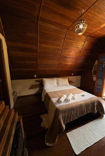 a bedroom with a bed with two towels on it at Pousada Cabanas do Visconde in Visconde De Maua