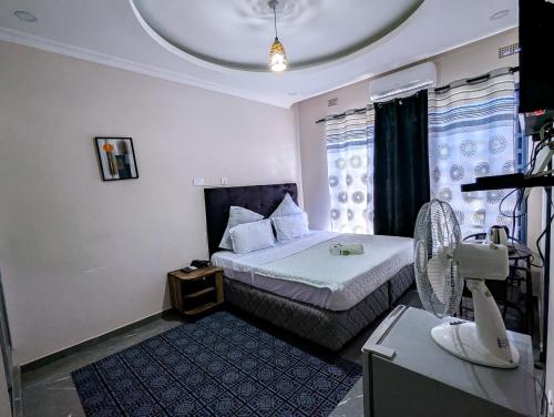 una piccola camera da letto con un letto e una finestra di Stay simple lodge a Lusaka