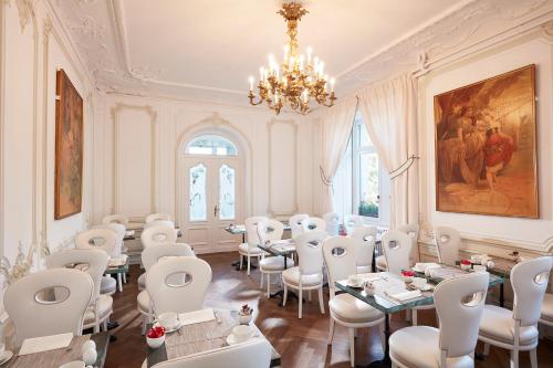 a dining room with tables and chairs and a chandelier at Hôtel Régent Contades in Strasbourg