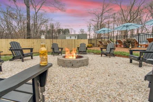 a fire pit in a yard with chairs and umbrellas at 5 Bdrm Family Retreat, Pool, HotTub, Golf, Firepit in Greensboro